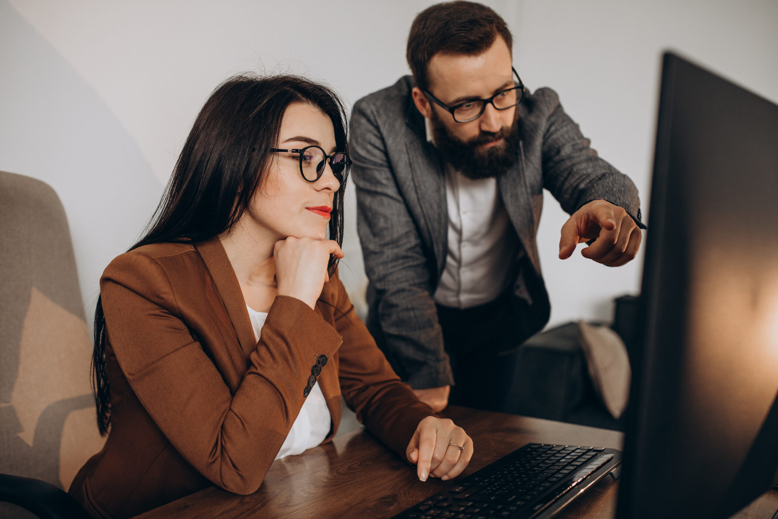 Two business partners working together in office on computer